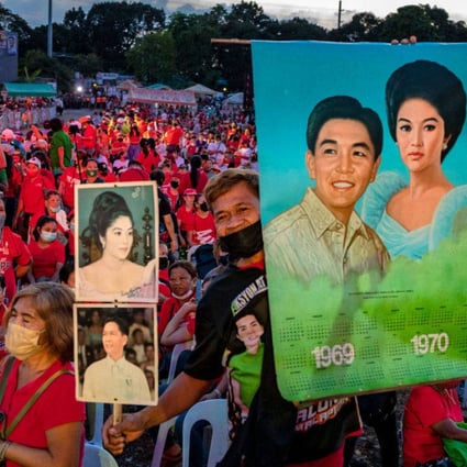 A supporter holds pictures of the late dictator Ferdinand Marcos and his wife Imelda Marcos at a Philippine presidential election campaign rally in Metro Manila. Photo: Getty Images