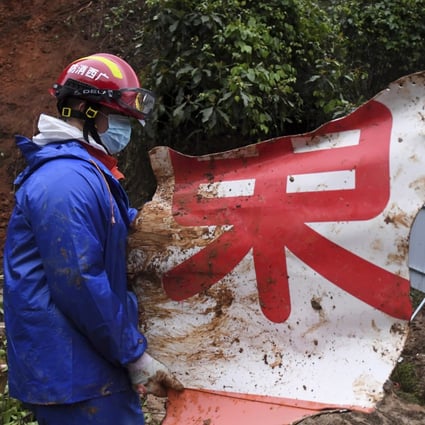 A rescue worker with a piece of debris at the plane’s crash site in southern China’s Guangxi Zhuang autonomous region. Photo: AP