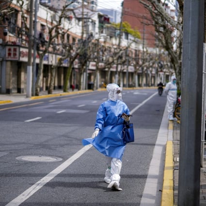 A worker in a protective suit keeps watch on a street, as the second stage of a two-stage lockdown  began in Shangha. Photo: Reuters