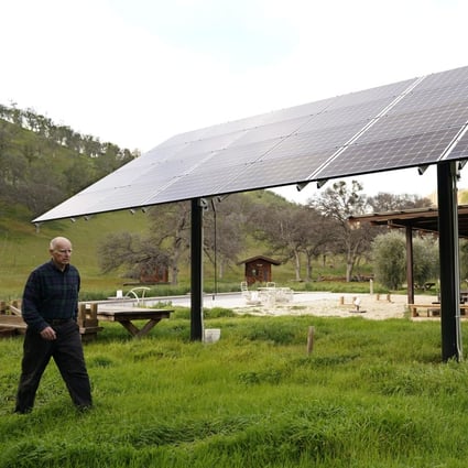 Former California governor Jerry Brown walks past one of the solar panels that power his home near Williams, California. Photo: AP