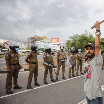 A man holds a Sri Lankan national flag during a protest, calling for the resignation of president over the alleged failure to address the economic crisis, outside the Parliament complex in Colombo, Sri Lanka on Thursday. Photo: EPA-EFE