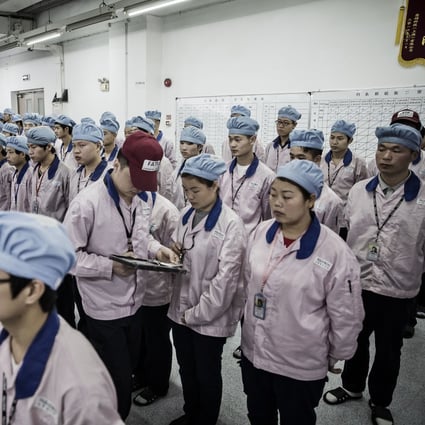 A supervisor holds an iPad as he checks an employee’s badge during roll call at a Pegatron factory in Shanghai. The company has suspended production in Shanghai and nearby Kunshan due to Covid-19 lockdowns. Photo: Bloomberg