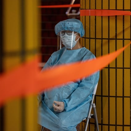 A health worker sits outside a building under lockdown on March 25. Frontline Covid-19 staff are experiencing burnout amid Hong Kong’s deadly fifth wave. Photo: EPA-EFE