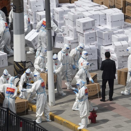Workers unload supplies including boxes of masks in Shanghai on April 10, 2022. Photo: Chinatopix via AP