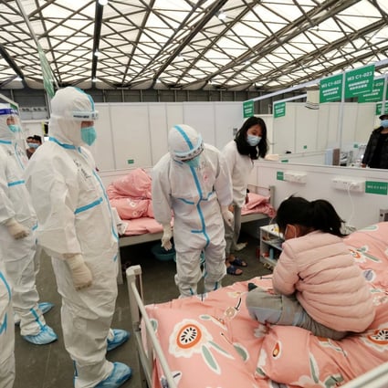 Medical workers in protective suits check on a child patient as they conduct ward rounds at Shanghai New International Exhibition Hall, which has been turned into a makeshift Covid-19 hospital in Shanghai. Photo: Reuters