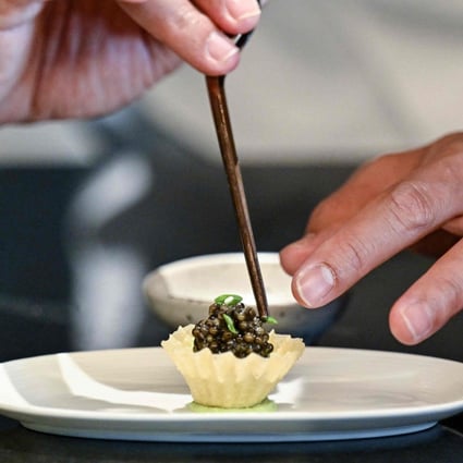 Chef Thitid “Ton” Tassanakajohn makes a dish using caviar from Thai Sturgeon Farm at his Lahnyai Nusara restaurant in Bangkok. Photo: AFP