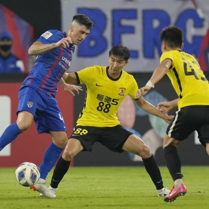 Fernando Forestieri of Johor Darul Ta’zim (left) fights for the ball against Guan Haojin of Guangzhou during their AFC Champions League group match. Photo: AP