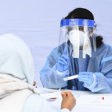 A health worker gives instructions to a person on how to carry out a Covid-19 swab test. Photo:  AFP via Getty Images/TNS 