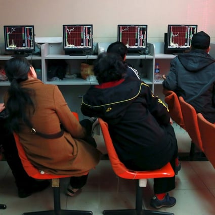 Investors look at computer screens showing stock information at a brokerage house in Shenyang in pre-pandemic days. Photo Reuters
