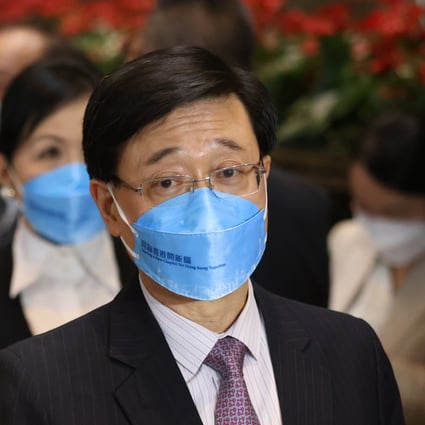 Chief executive hopeful John Lee Ka-chiu, wearing a mask bearing his campaign slogan “Starting a New Chapter for Hong Kong Together”, meets the media at Central Plaza in Wan Chai on April 18. Photo: Nora Tam