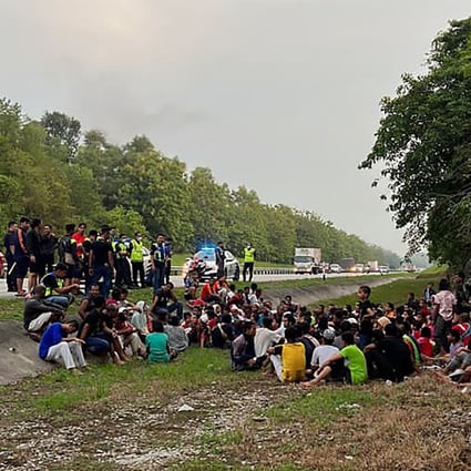 Malaysian police with some of the hundreds of Rohingya refugees who escaped from a detention centre in Penang on Wednesday. Photo: Malaysia Royal Police via AP