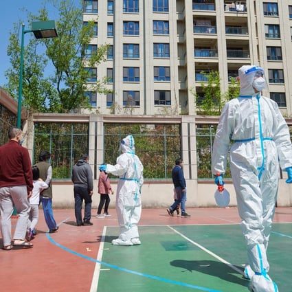 Community volunteers wearing personal protective equipment organise residents for a Covid-19 test in a compound during a lockdown in Pudong district in Shanghai on April 17, 2022. Photo: AFP
