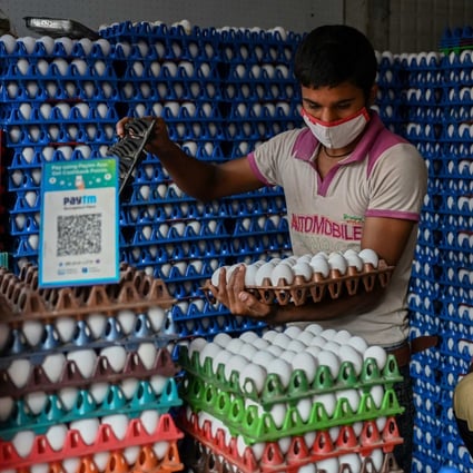 Men work at a poultry shop with a QR code displayed for Paytm, an Indian cellphone-based digital payment platform, in Mumbai. Photo: AFP
