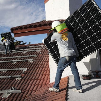 Workers install solar panels on the roof of a home in Palmetto Bay, Florida, US, on January 23, 2018. Photo: AFP