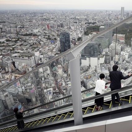 Visitors look at the view while riding on an escalator at the Shibuya Sky observation deck of the Shibuya Scramble Square building in Tokyo. Photo: Bloomberg