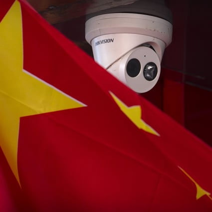 A Chinese flag hangs near a Hikvision security camera outside of a shop in Beijing. Photo: AP