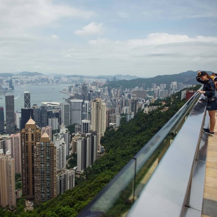 Tourists stand on the viewing platform of Victoria Peak in front of the Hong Kong skylineon August 19, 2019. Photo: Getty Images
