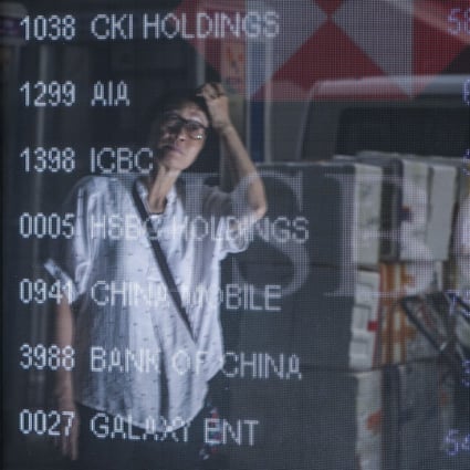 A pedestrian looks at the electronic monitor displaying stock prices outside a bank in Mong Kok, Hong Kong. Photo: Winson Wong