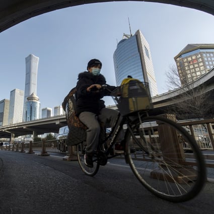 Pedestrians and cyclists travel past buildings in the central business district in Beijing. China is expected to end its regulatory clampdown on Big Tech as the economy slows. Photo: Bloomberg
