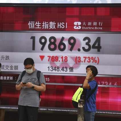 People passing by a board showing the Hang Seng Index in Central, Hong Kong on April 25. Photo: K. Y. Cheng