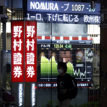 Illuminated signage for Nomura Securities, a unit of Nomura Holdings, displayed outside one of the company’s branches at night in Tokyo on April 25, 2022. Photo: Bloomberg