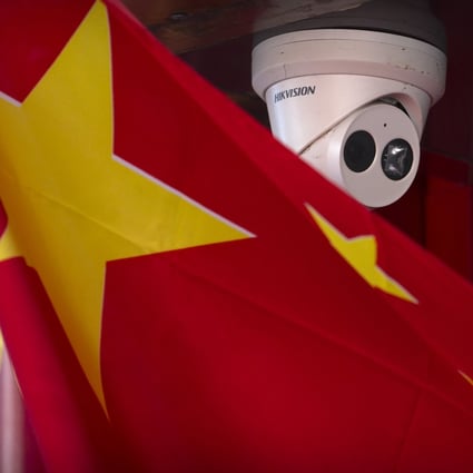 A Chinese flag hangs near a Hikvision security camera outside of a shop in Beijing. Shares of the Chinese surveillance camera maker plunged again on Friday after a report that the US is considering fresh sanctions. Photo: AP Photo