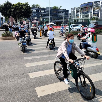 Shenzhen residents ride scooters and bicycles along a street on March 21, after the city was reopened following a week-long lockdown to combat a Covid-19 outbreak. Photo: AFP