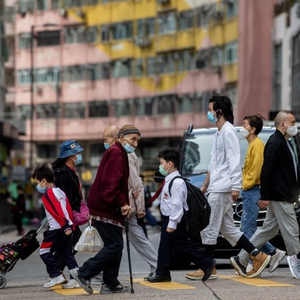 Pedestrians cross a road in Hong Kong on December 7, 2021. Enduring assumptions about the city’s population growth are now moot. Photo: Bloomberg