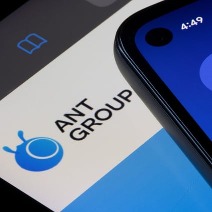 The Alipay app icon is seen on a smartphone on top of an iPad screen showing the homepage of Ant Group. Photo: Shutterstock