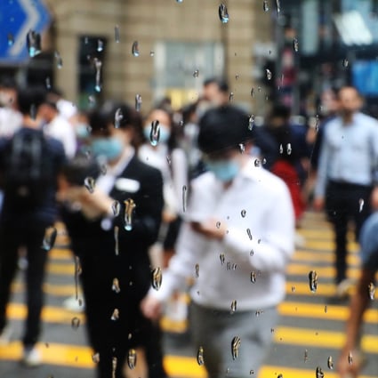 Office workers are seen through a window as they cross a road in Central. Photo: Nora Tam