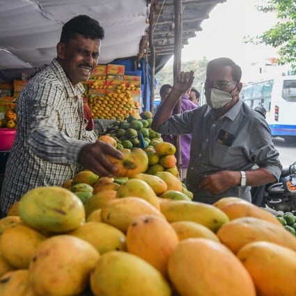 A customer buys mangoes at a stall in Bangalore, India. Photo: AFP
