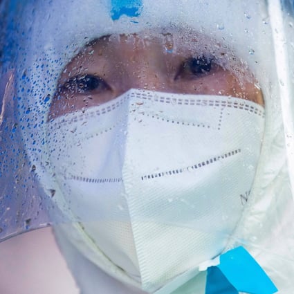 A community volunteer looks on while residents undergo nucleic acid tests for the Covid-19 coronavirus in a compound under lockdown in the Pudong district in Shanghai. Photo: AFP
