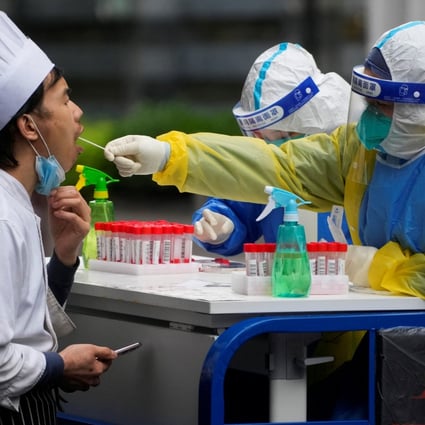 A medical worker in a protective suit collects a swab sample from a chef for nucleic acid testing, during lockdown, amid the coronavirus disease (COVID-19) pandemic, in Shanghai on May 13, 2022. Photo: Reuters