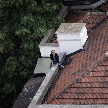 A man sits on the roof of his home in Shanghai. Residents of lockdown zones in Yangpu district, the location of many of Shanghai’s universities, are under a three-day ‘silent period’ and are confined to their homes to ensure zero contact with outsiders. Photo: EPA-EFE