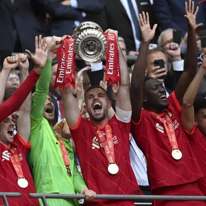Jordan Henderson lifts the trophy as Liverpool celebrate after winning the FA Cup final against Chelsea at Wembley. Photo: EPA-EFE