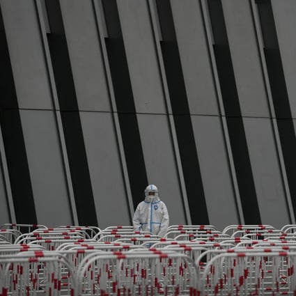 A worker in a protective suit stands watch near the barricades at a testing site as the authorities order a third round of coronavirus tests for residents of Beijing’s Chaoyang district on May 8. Photo: AP 