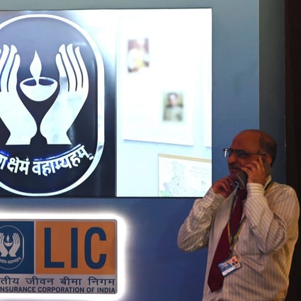 A man speaks on his mobile phone standing next to a Life Insurance Corporation of India (LIC) sign ahead of the company’s listing ceremony at the Bombay Stock Exchange (BSE) in Mumbai on Tuesday. Photo: AFP