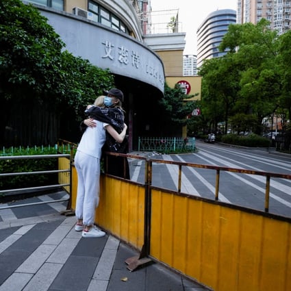 Two women hug at a closed street during lockdown, amid the coronavirus disease (COVID-19) pandemic, in Shanghai on May 16, 2022. Photo: Reuters