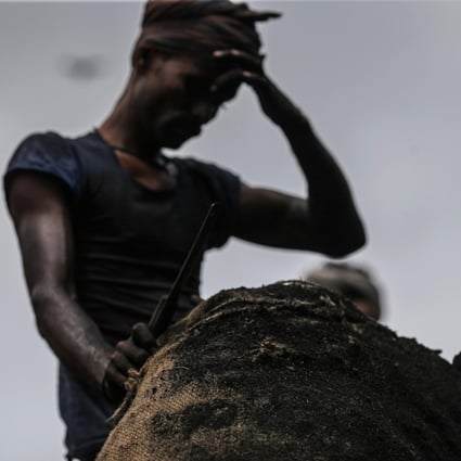 A worker unloads a sack of charcoal from a truck at a wholesale market in Mumbai on August 9. Photo: Bloomberg