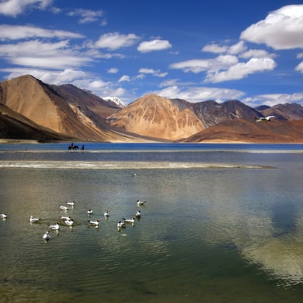 An Indian tourist rides on a horse at Pangong lake high up in Ladahak region of India. Photo: AP