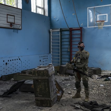 A Ukrainian serviceman inspects a school damaged in fighting with Russian troops in a village outside Kharkiv, in eastern Ukraine. Photo: AP