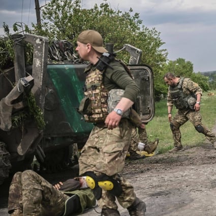 Ukrainian servicemen assist their comrades not far from the frontline in the eastern Ukrainian region of Donbas. Photo: AFP