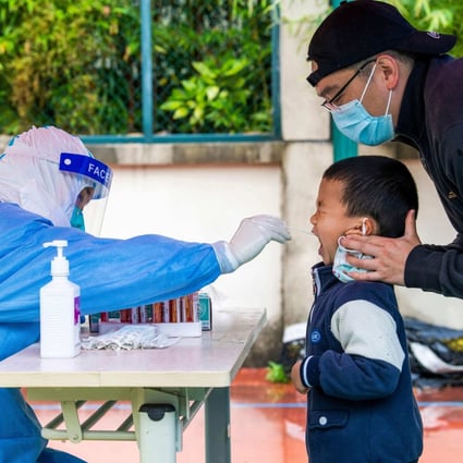 A health worker takes a swab sample from a child to be tested for Covid-19 in a compound under lockdown in the Pudong district of Shanghai on May 13, 2022. Photo: AFP