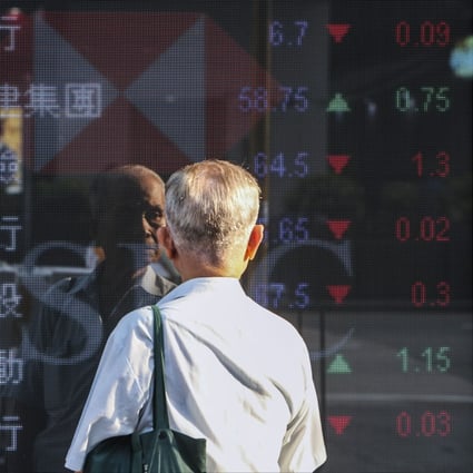 An elderly looks at the electronic screen displaying stock prices outside a bank in Hong Kong. Photo: Winson Wong