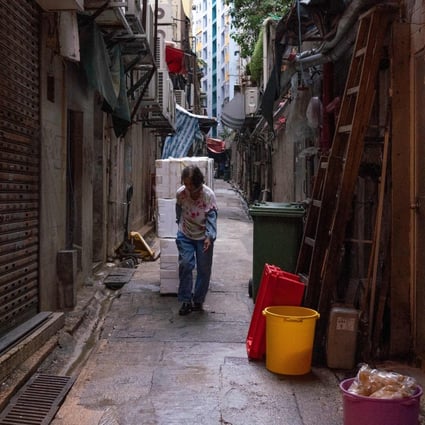 A woman pulls styrofoam boxes in an alley in Kwun Tong on October 21, 2021. Photo: AFP
