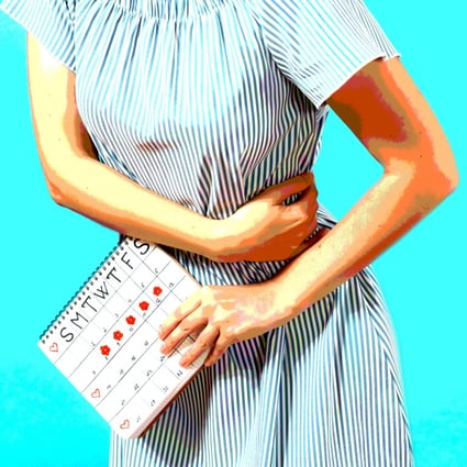 A woman in a blue dress holds a calendar to check her menstruation days. Photo: Shutterstock