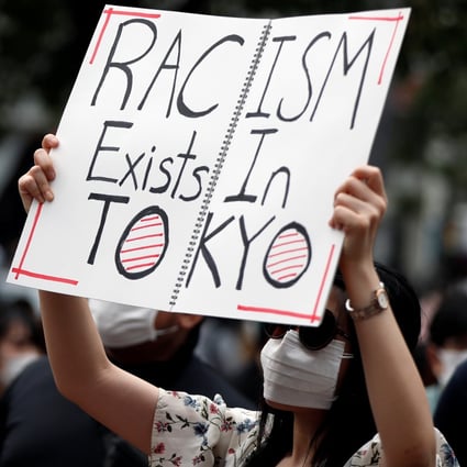 A demonstrator holds a placard during a protest march in Japan in 2020. Photo: Reuters