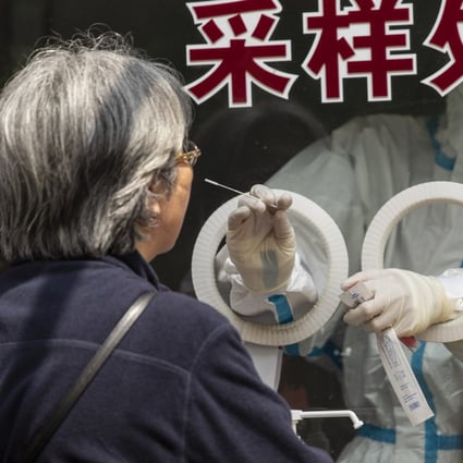 A healthcare worker in personal protective equipment (PPE) takes a swab sample at a Covid-19 testing centre in Shanghai, May 27, 2022. Photo: Bloomberg