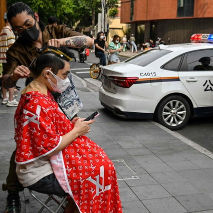 A man having a haircut on a street during a lockdown in Shanghai on May 27 as restrictions are gradually eased. Photo: AFP