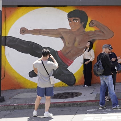 People stop to take pictures by a Chinatown mural of martial artist Bruce Lee in San Francisco. Photo: AP
